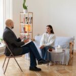 Séance thérapeutique dans un cabinet lumineux, illustrant la pratique professionnelle précédant la facturation pour les sophrologues