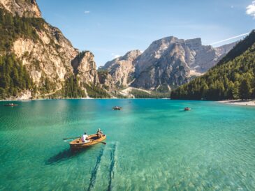 three brown wooden boat on blue lake water taken at daytime