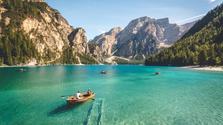 three brown wooden boat on blue lake water taken at daytime