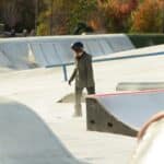 a man standing on a skateboard ramp at a skate park