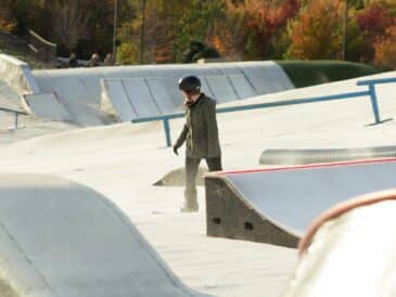 a man standing on a skateboard ramp at a skate park