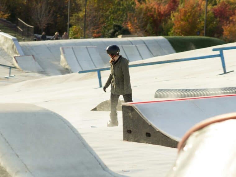 a man standing on a skateboard ramp at a skate park