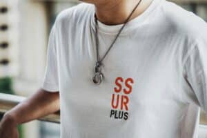 a man wearing a white tshirt and a necklace