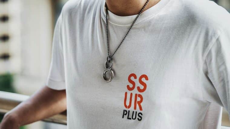 a man wearing a white tshirt and a necklace