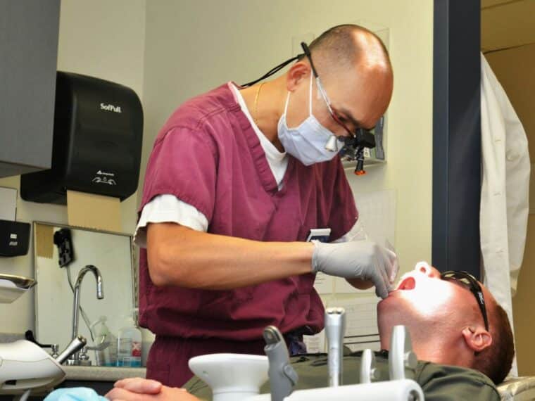 Dentist examining a patient's teeth in a clinic.