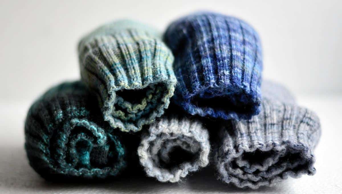 Cinq chaussettes tricotées de couleurs variées roulées sur fond blanc Cinq chaussettes tricotées de couleurs variées roulées sur fond blanc