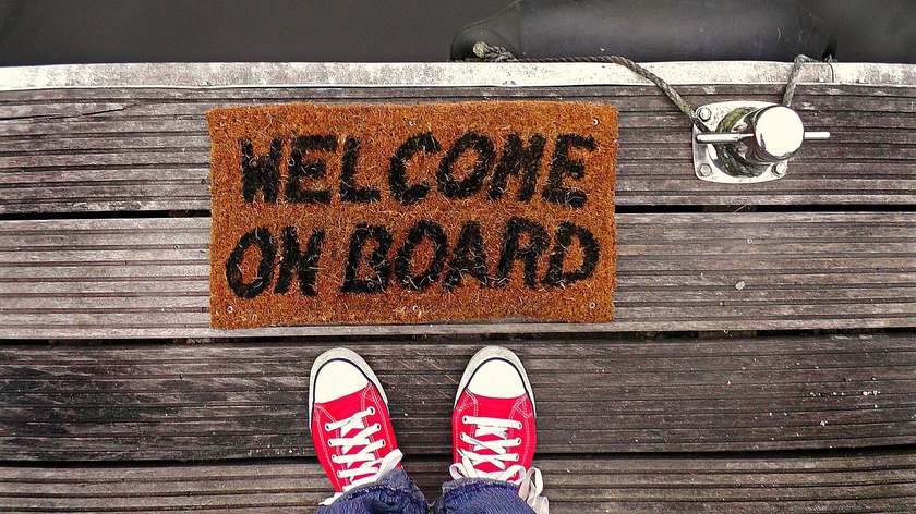 Pieds en Converse sur plancher bateau tapis bienvenue